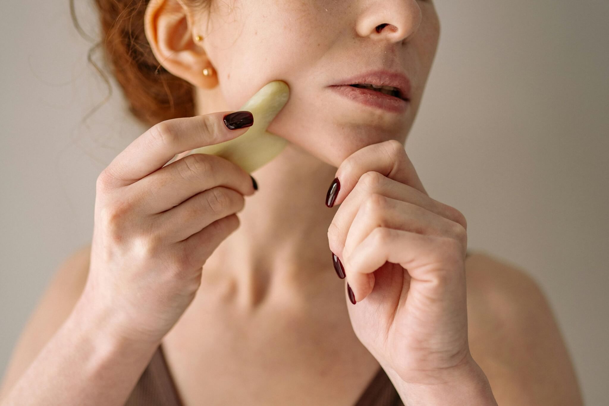 femme prenant soin de son visage avec un gua sha